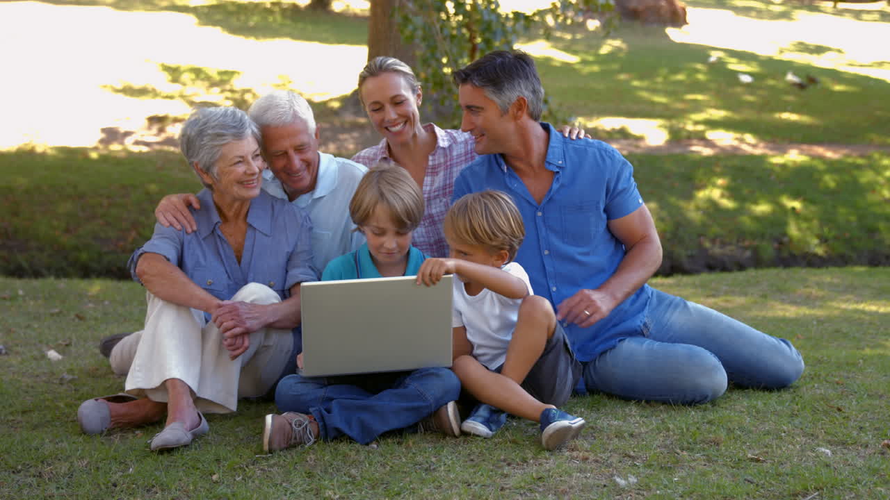 Happy family using laptop together in the park