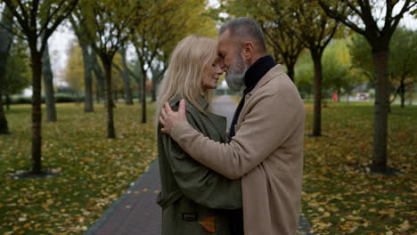 Beautiful-lovers-standing-together-facing-each-other-in-romantic-autumn-park.