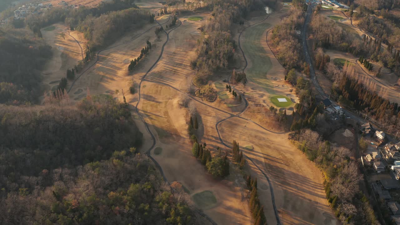 una inclinación aérea de un relajante campo de golf de montaña en el campo
