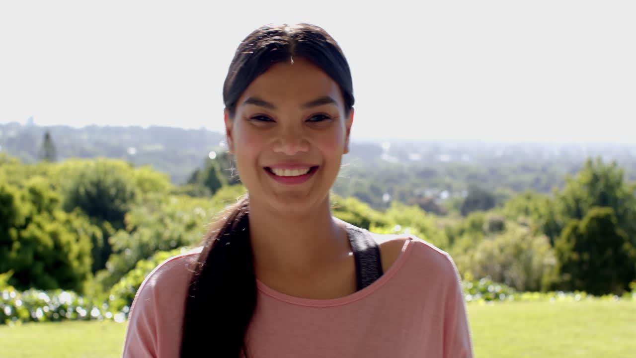 Smiling woman enjoying sunny day outdoors in lush green park