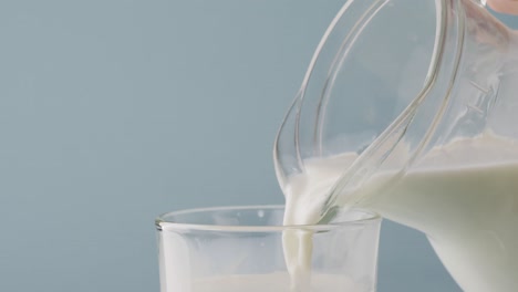 video of glass and jug of milk with copy space on blue background