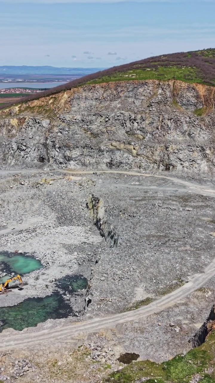 Aerial shot of quarry edge and large lake shoreline