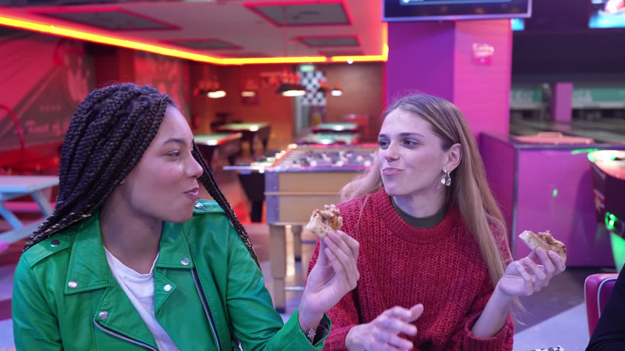 Due donne che mangiano pizza in un ristorante