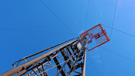 looking at the tall metal support at the site for oil production. low angle view at the derrick for drilling gas.