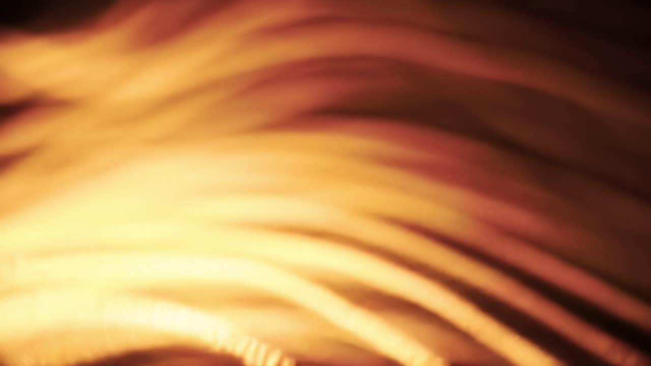 Waves of warm light create mesmerizing patterns as day transitions into night in a bustling city environment. The glow captivates viewers with dynamic shapes and textures.