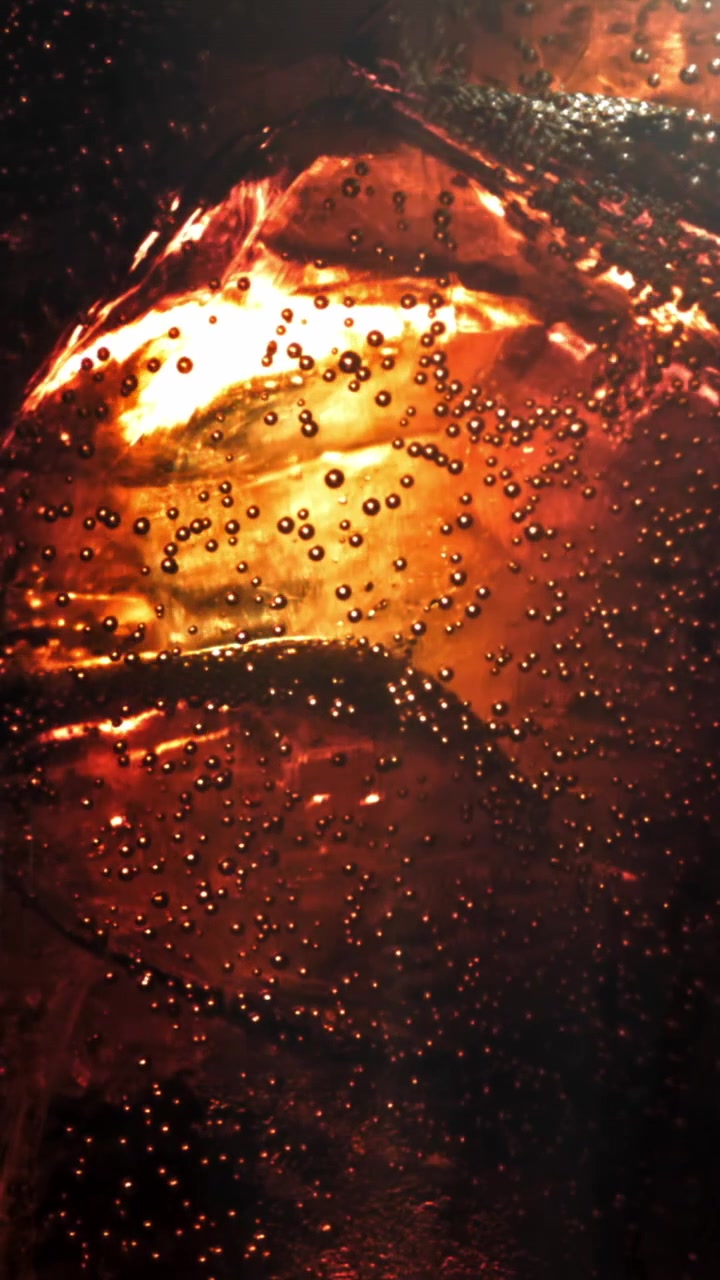 Primo piano di bevanda gassata rinfrescante con bollicine e ghiaccio