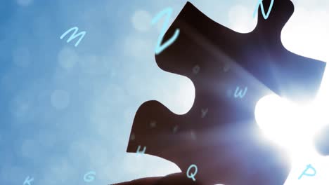 Animation-of-puzzle-pieces-and-letters-falling-over-blue-background