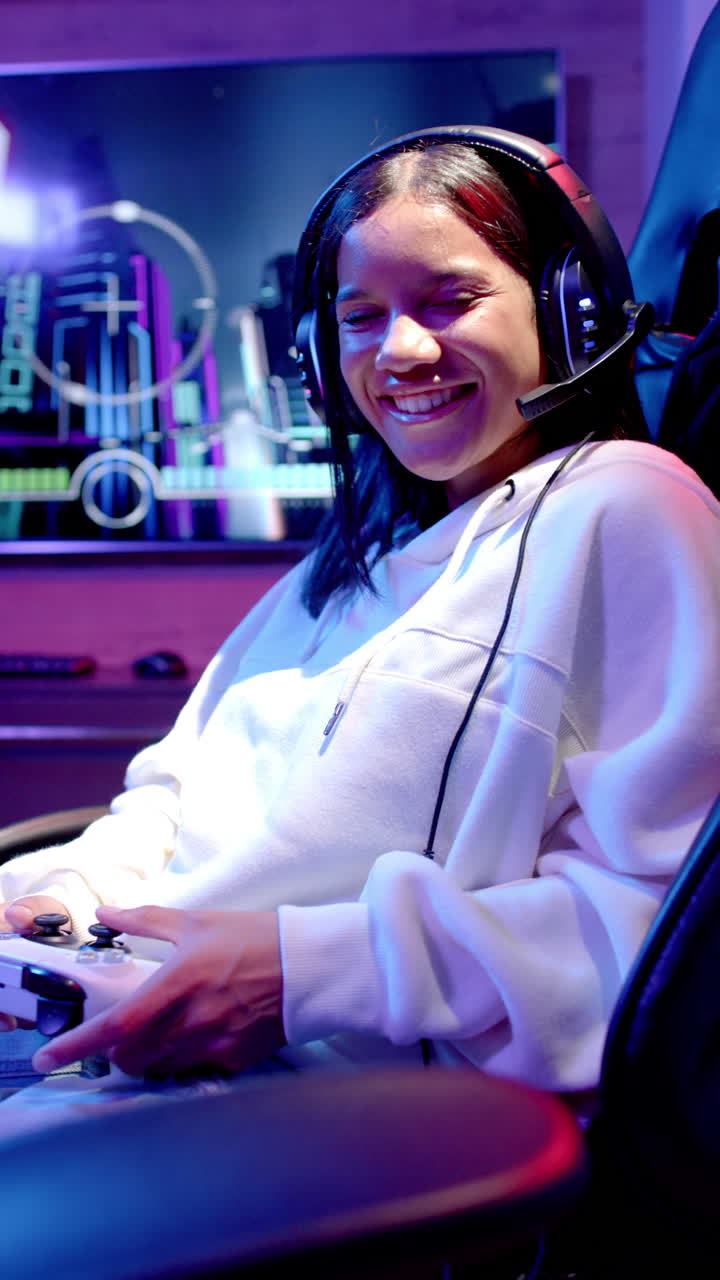 Vertical video: Playing video games, teenage girl smiling and wearing headset in gaming setup