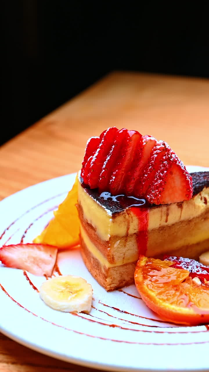 Strawberry cake slice closeup. A rich layered cake slice topped with fresh strawberries and syrup