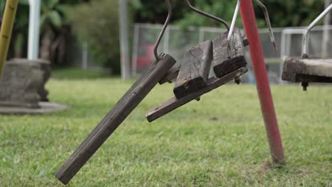 broken wooden swing in public park