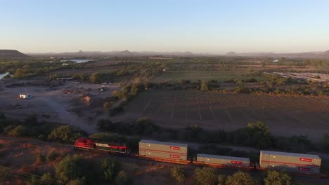 toma aérea de un gran tren de carga en sonora al atardecer