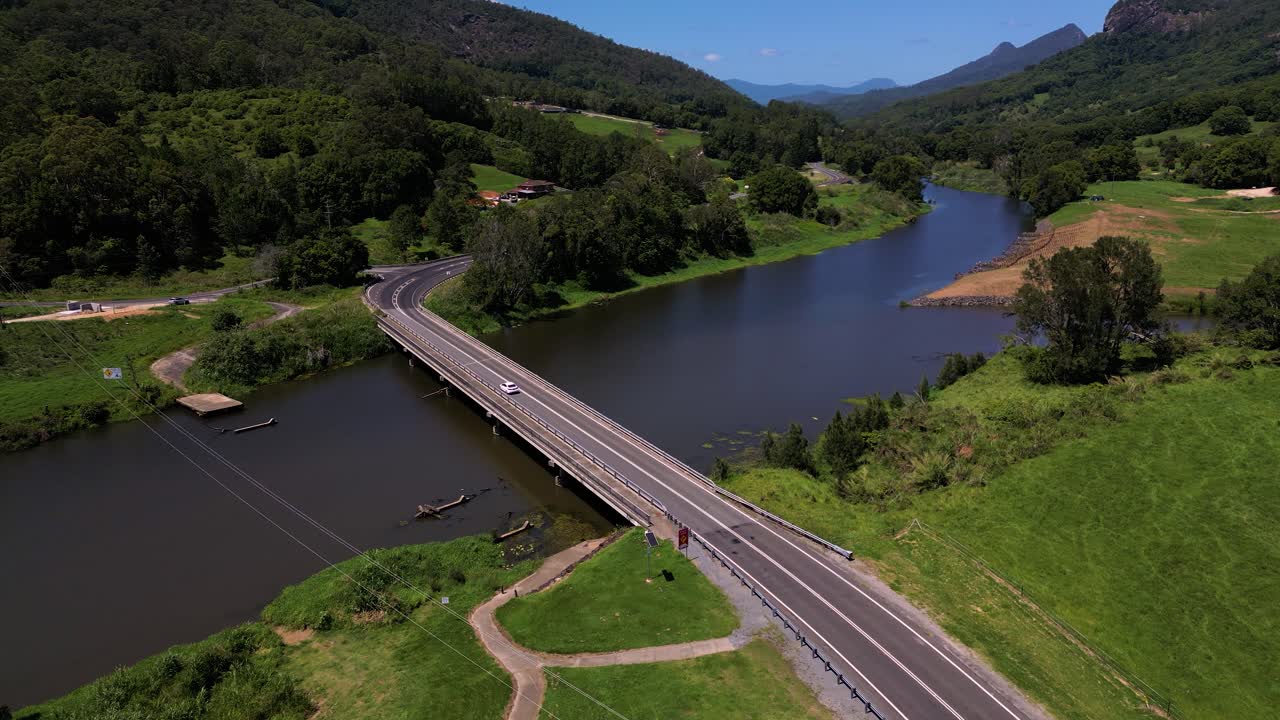 A car drives over a bridge over the Tweed River near Mt Warning, Wollumbin on a sunny day in New South Wales, Australia