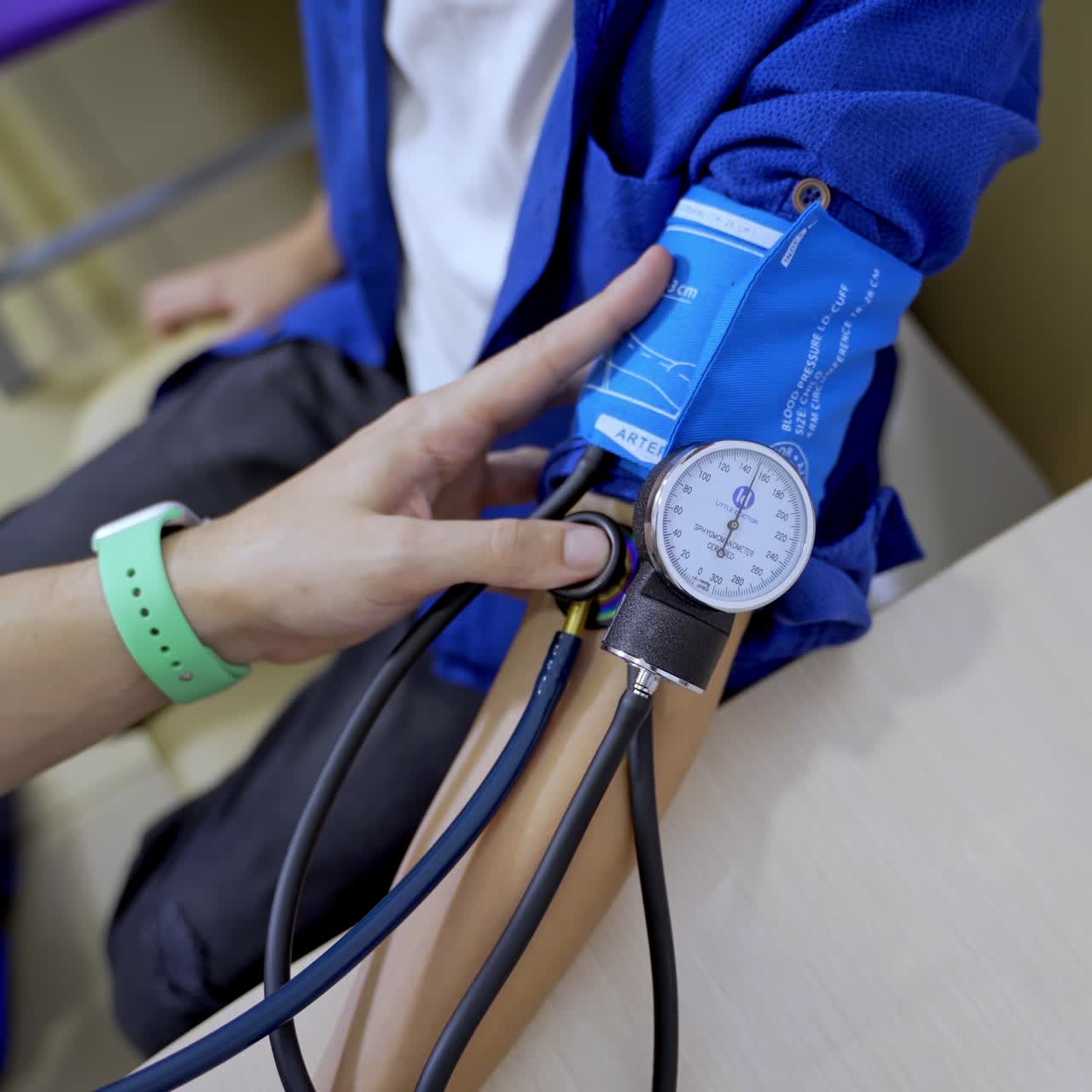 Pediatrician is measuring blood pressure of boy teenager. Selective focus on apparatus. Pediatric concept