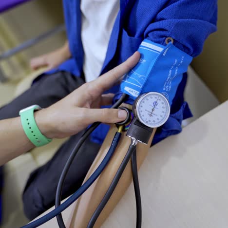 pediatrician is measuring blood pressure of boy teenager. selective focus on apparatus. pediatric concept