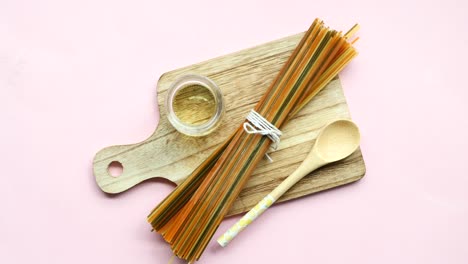 colorful pasta and olive oil on a wooden cutting board