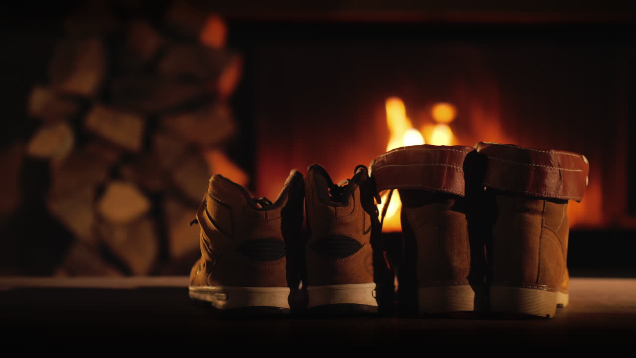 남자와 여자의 겨울 부츠는 낭만적인 겨울 저녁 벽난로 근처에서 건조