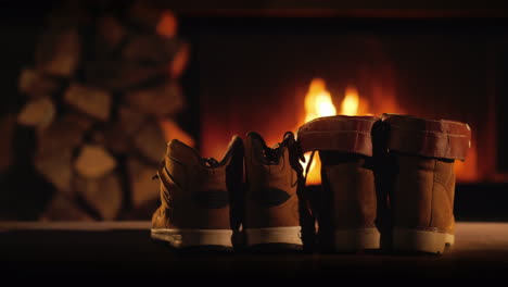 men's and women's winter boots dry near the fireplace romantic winter evening