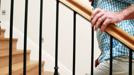 senior man climbing upstairs with walking stick