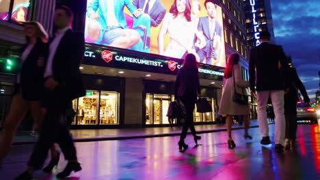 city street at night with pedestrians and store fronts