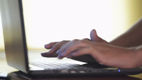 hands typing on a laptop keyboard