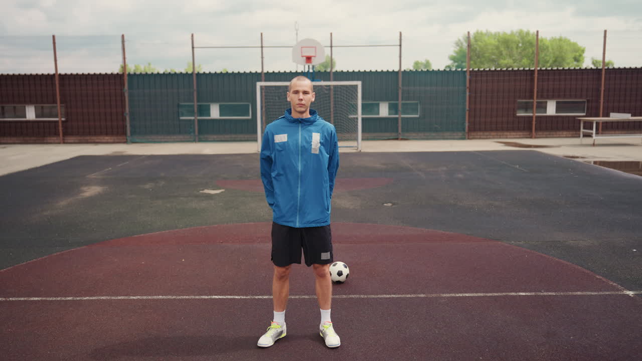 Treinador em ambiente de esportes aquáticos observando atentamente, dia chuvoso em campo com instrutor de futebol determinado presente, tempo nublado cercando o treinador concentrado em campo de futebol úmido com equipamento