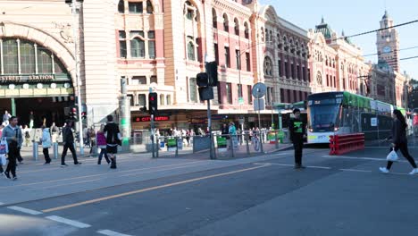 people crossing street near train station