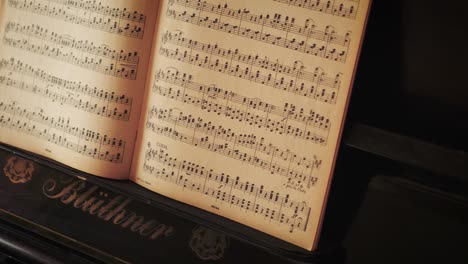 Notes-chart-on-an-old-Blüthner-grand-piano,-slow-tripod-tilt-up-shot