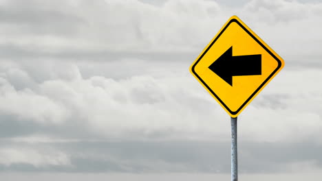 Animation-of-left-side-arrow-signboard-against-clouds-in-the-grey-sky