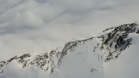 Dramatic-aerial-view-of-mountain-cliffs-in-the-winter-in-British-Columbia,-Canada