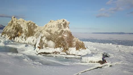 frozen lake with rock formation and people