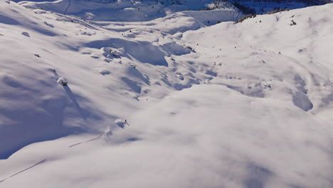 aerial footage of the iconic freeride paradise of verbier on a stunning bluebird day. snow-covered peaks, wide open faces, and legendary off-piste terrain under clear alpine skies