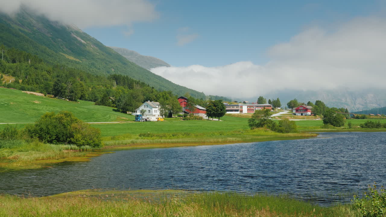 paisaje escénico de noruega - a lo largo del lago hay un camino en el fondo hay montañas 4k