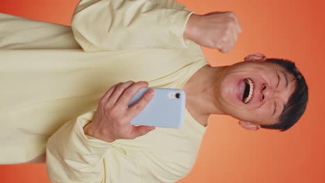 feliz emocionado hombre asiático usar teléfono inteligente decir wow sí descubrió gran gran victoria noticias haciendo gesto ganador