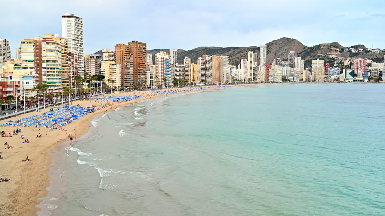 Panoramic view of a beach in Benidorm, Spain with buildings on the background