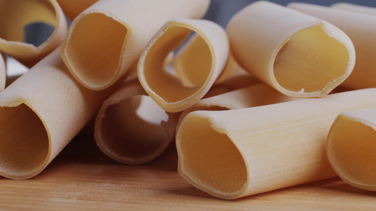 Primo piano di cannelloni crudi su una superficie di legno