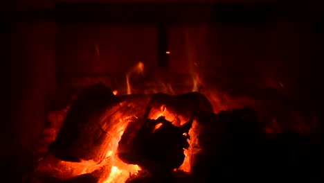 full screen view of fire in a wood stove with sparks