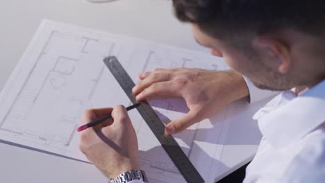 the architect organizes and renews perspective drawings at his desk in the architecture office.