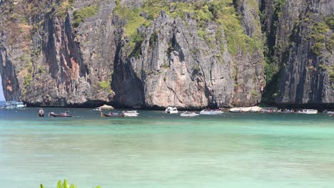 boats moving near tropical limestone cliffs