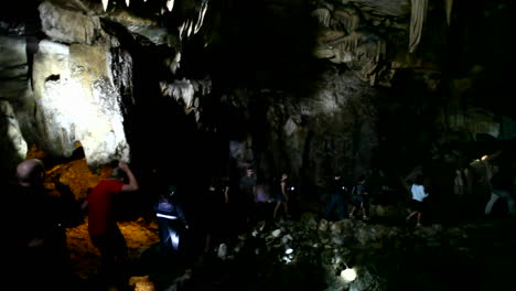 people explore a dark cave with flashlights