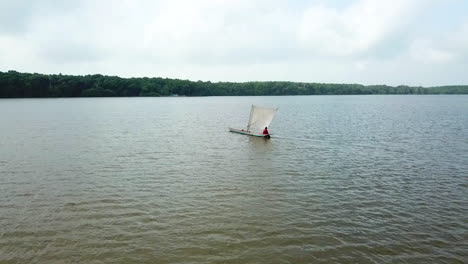 Local-fisherman-fishing-on-a-wooden-sail-boat-in-open-water-in-South-America