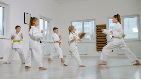 niños en kimono blanco en la clase de artes marciales