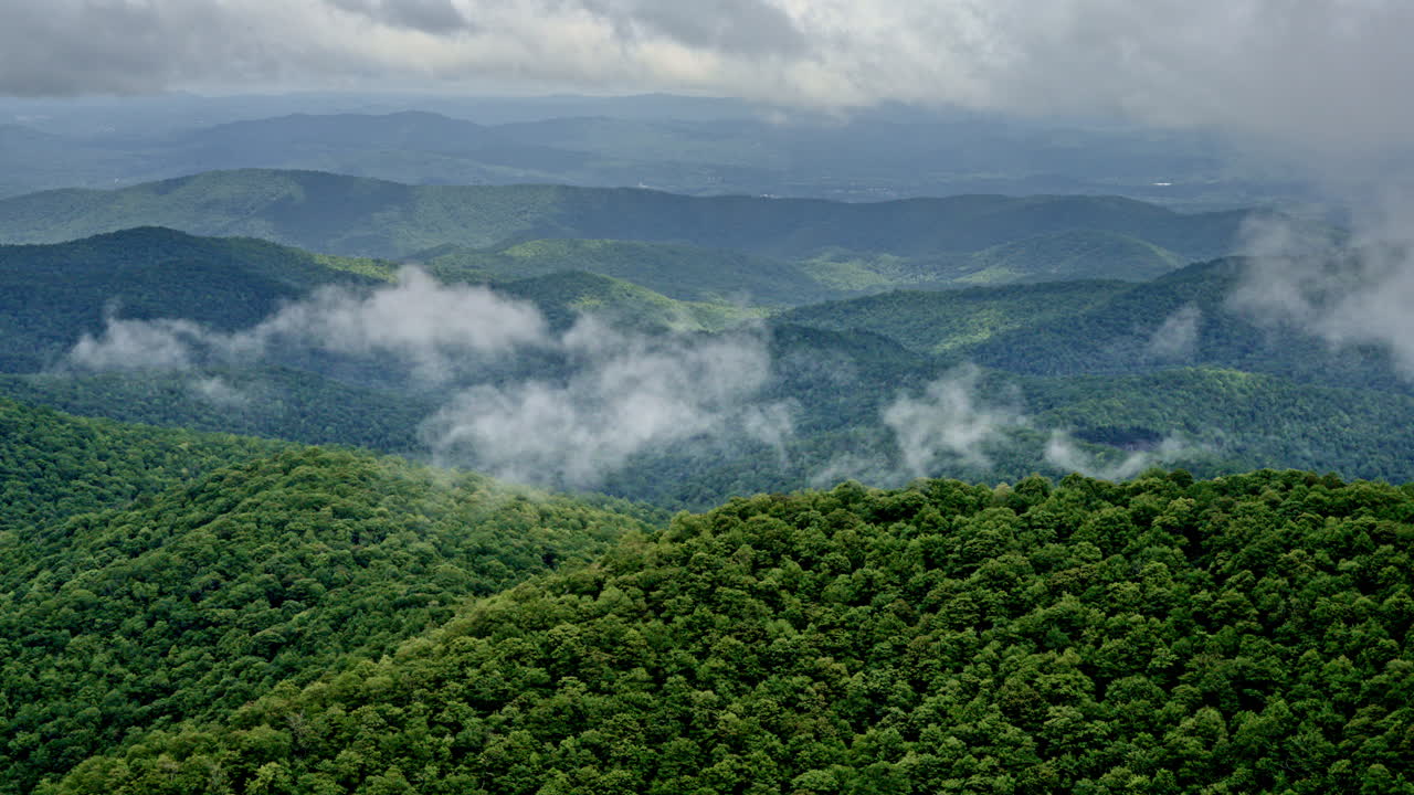 Drone cruises above mist-swirled ridges and valleys in a soaked Smoky landscape