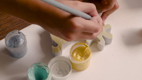 close up view of girl's hands painting animal pieces on the floor 1