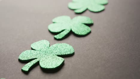 video of saint patricks day green shamrock leaves on black background