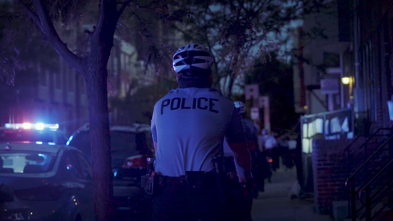 Police officers ride their bikes as the camera sharply tracks them in slow-motion.