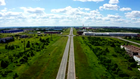 road with round junction near industrial complex aerial view