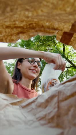 woman eating a hamburger in a park