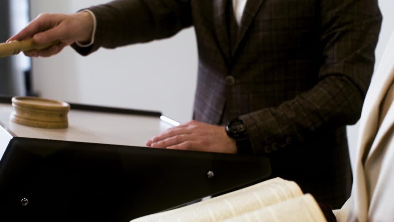 Man in elegant suit with gavel and woman holding book
