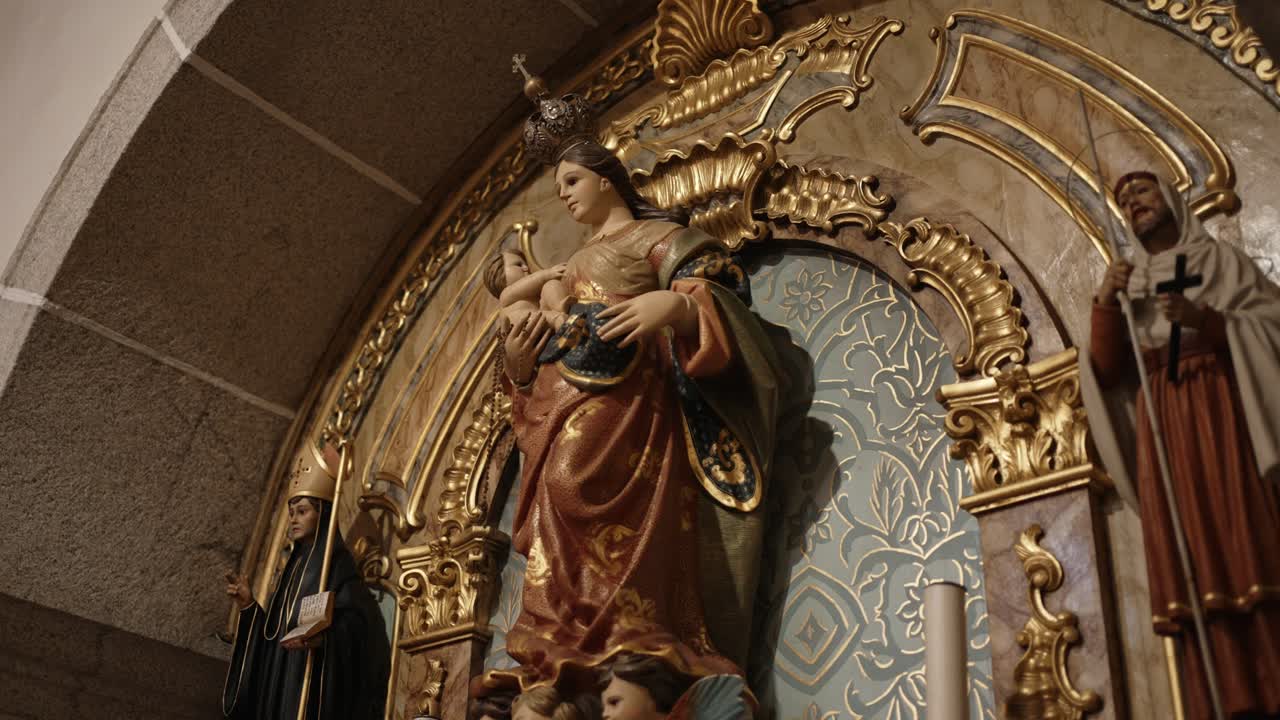 Close up of Madonna and Child statue on a richly decorated golden baroque church altar