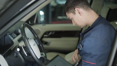 mechanic performing car diagnostics with laptop